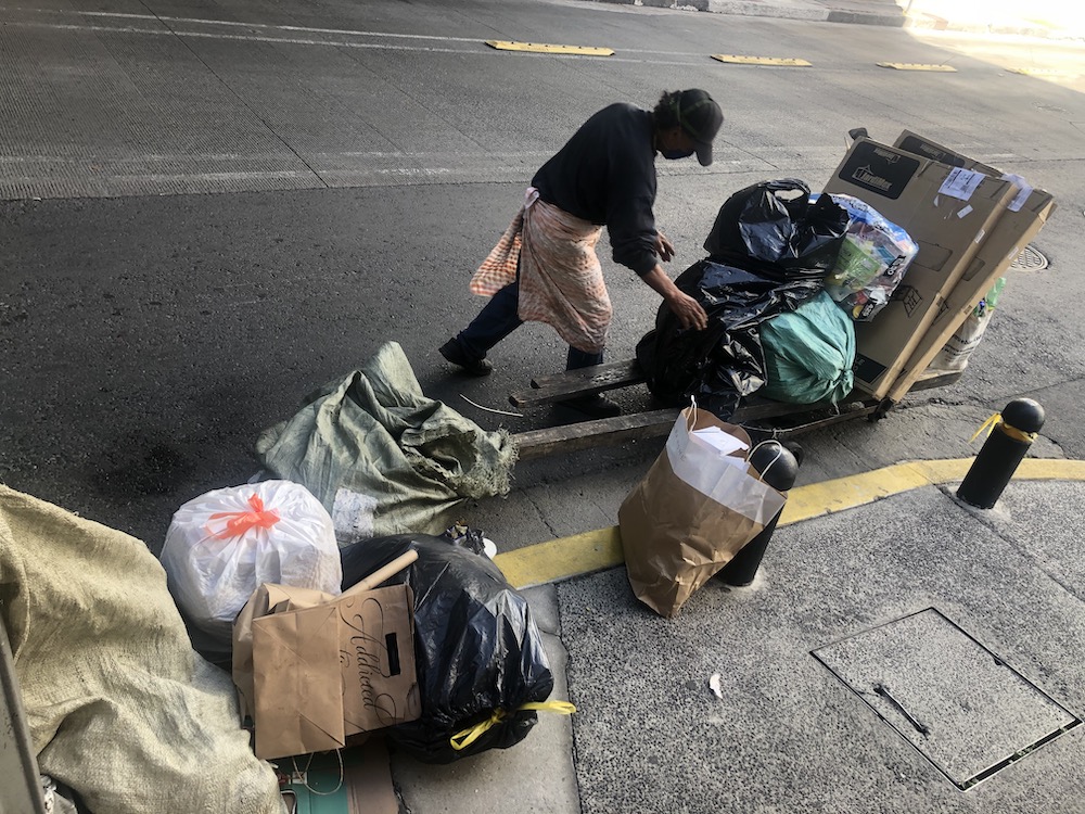 Un recolector voluntario separa en la vía pública los residuos reciclables que recuperó, para venderlos. Foto: Claudia Altamirano.